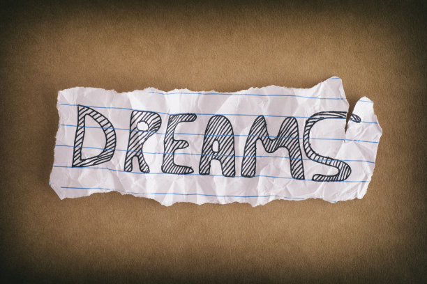 一张皱巴巴的纸，上面写着“梦想”，背景是牛皮纸图片下载