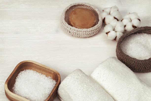 温泉设置在白木上。棉花植物蓬松的花，盒子里的海盐，干净的毛巾，肥皂在木制的背景与复制空间。前视图。健美的照片。图片下载