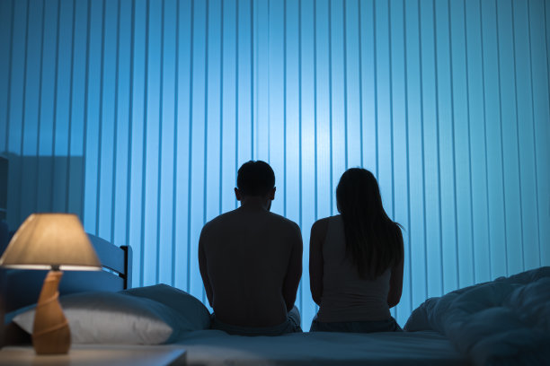 男人和女人坐在床上。晚上的时间图片下载