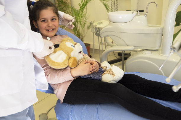 小女孩用泰迪熊治疗她的牙齿图片下载