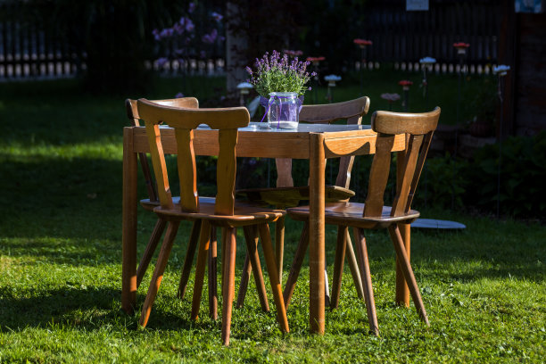 在一个美丽的花园里，摆着木桌和椅子图片下载