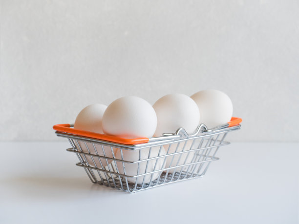 复活节简约的概念。白色的背景下，白色的鸡蛋放在金属食物篮子里图片下载