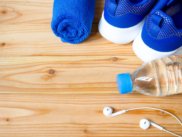 运动鞋，一瓶水，耳机和毛巾图片下载