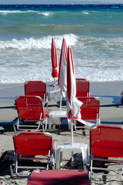 波涛汹涌的大海，空荡荡的红色躺椅和阳伞图片下载