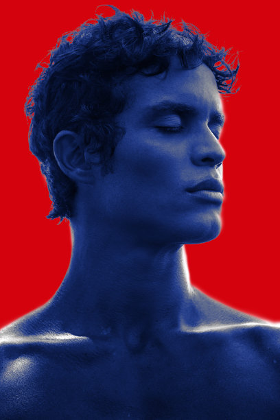 一个健康的侧面肖像，赤裸的胸部与黑色的头发和强壮的特征，以红色的背景图片下载