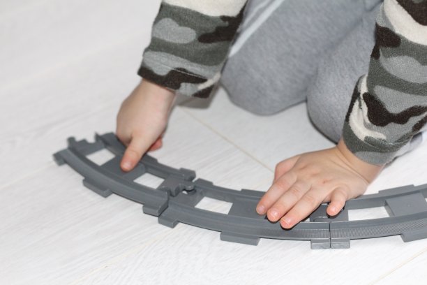 一个小男孩在修铁路。婴儿在玩。图片下载