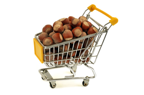 白色背景下装满榛子的超市手推车图片下载