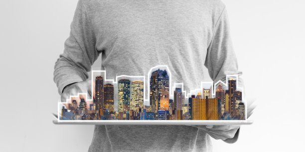 房地产商业、建筑科技和智慧城市。一个男人在用带有建筑物全息图的数字平板电脑图片下载