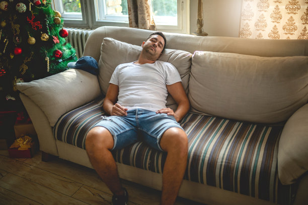 疲惫的男人睡在客厅的沙发上图片下载