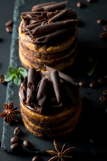 巧克力蛋糕在黑色木板薄荷，咖啡豆在黑暗的背景，特写照片。新鲜、美味的甜品理念。图片下载