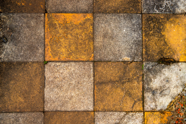 旧的黄色和白色铺设裂缝，俯视图照片为背景。陶瓷铺平道路纹理。图片下载