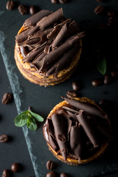 巧克力蛋糕在黑色木板薄荷，咖啡豆在黑暗的背景，特写照片。新鲜、美味的甜品理念。图片下载