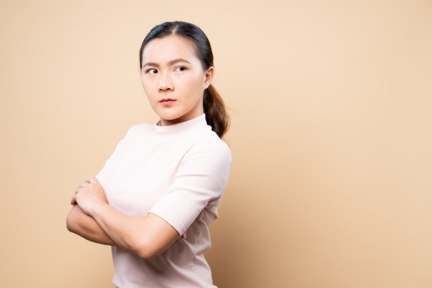 愤怒的女人孤立地站在米黄色的背景上图片下载