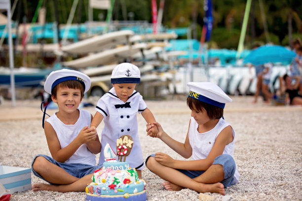 可爱的小男孩和他的兄弟们，用海洋主题的蛋糕和装饰庆祝他们的一岁生日图片下载