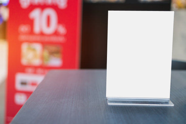 白色模型亚克力框架海报模式模板形成背景在桌子上的信表准备使用显示您的产品，模糊的背景插入为客户的文本。发短信的空间。图片下载