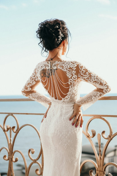 时尚照片美丽的新娘与黑色的头发在豪华的婚纱摆姿势在卧室图片下载