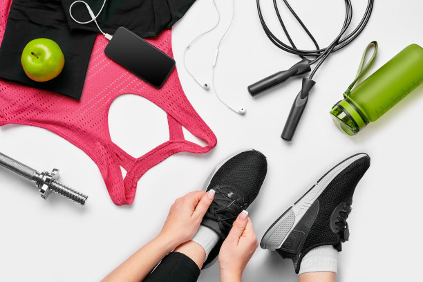 头顶上的女人手系鞋与运动设备在白色的背景图片下载