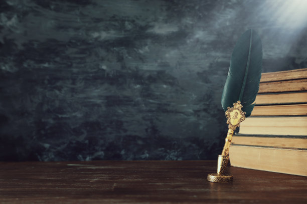 旧羽毛笔墨水瓶和旧书在木桌上，在黑色的墙壁背景。关于历史、幻想、教育和文学主题的概念性照片图片下载