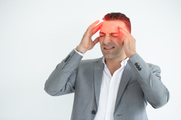 头痛的商人。一名男子孤立在白色背景上，用手指摩擦他的太阳穴，因为他有头痛。图片下载