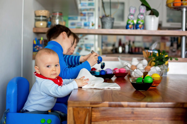 三个孩子，兄弟，在家里的厨房里涂画复活节彩蛋图片下载