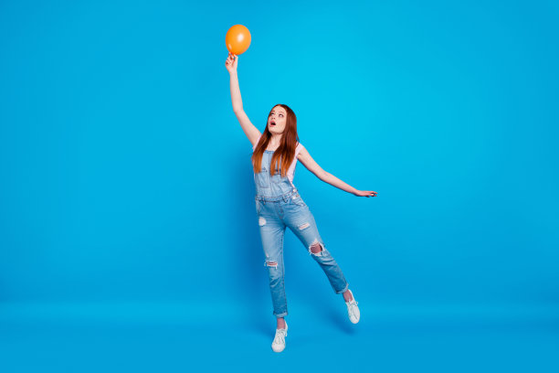 全身的身体尺寸照片美丽的惊人的她她的夫人周末玩气球最终开始开始飞上天空意外的穿休闲牛仔裤牛仔工作服衣服孤立的蓝色背景图片下载