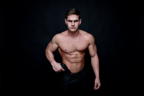 赤裸上身的肌肉男拿着一把手枪图片下载