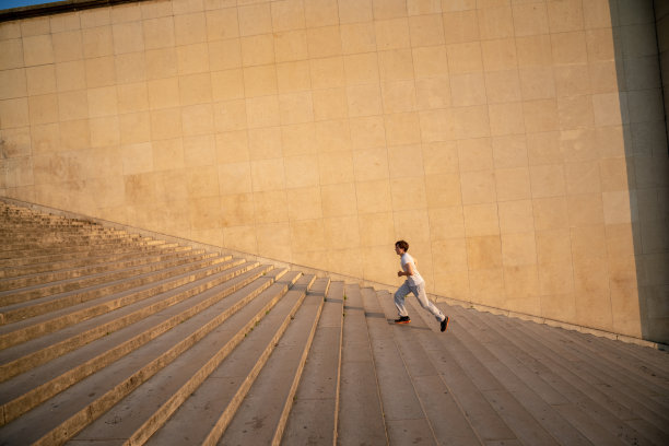 健康的年轻人靠着墙跑上楼梯图片下载