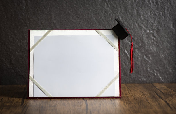 毕业帽上带毕业证书，教育观念上带木色背景图片下载