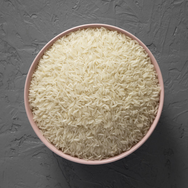 干白的印度香米放在一个粉红色的碗里，灰色的背景，俯视图。平躺着，从上面俯视。图片下载