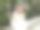 户外肖像美丽的中国妇女在白色的裙子微笑在粉红色的玫瑰墙花园，快乐的女孩享受她的闲暇时间。图片下载