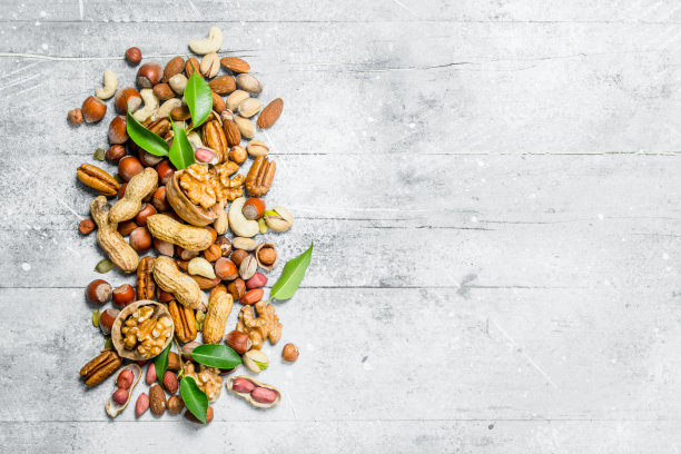 坚果的背景。各种带叶子的坚果。图片下载