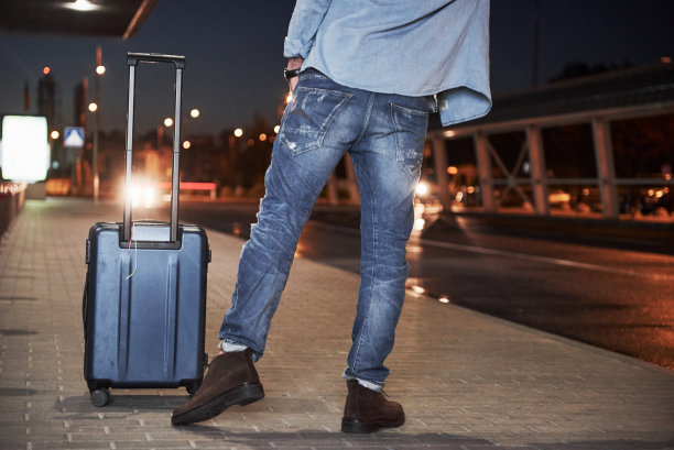 一名拿着行李的男性旅客站在深夜里叫车图片下载