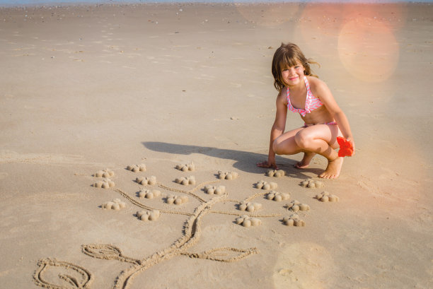 美丽的女孩在沙滩上画画图片下载