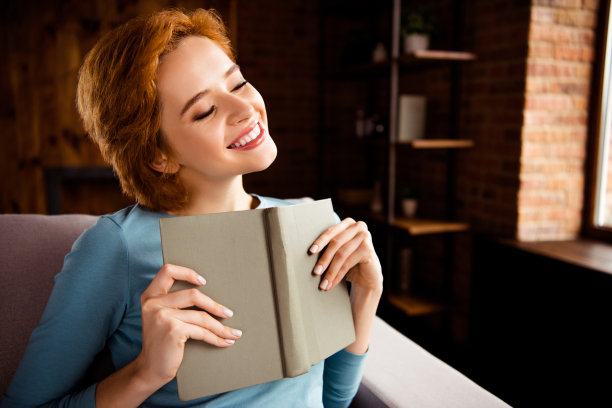 近距离的照片美丽的她她的手手臂冒险书短发想象飞行眼睛闭上假装自己的主角穿着蓝色的套头衫牛仔裤牛仔坐在沙发房子客厅室内图片下载