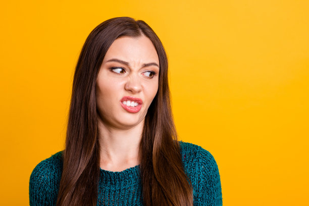 近距离的照片惊人的美丽的她，她，夫人限制恶心的看一边空的空间，面部表情变质的食物吃穿着绿色针织套衫，毛衣孤立的黄色背景图片下载