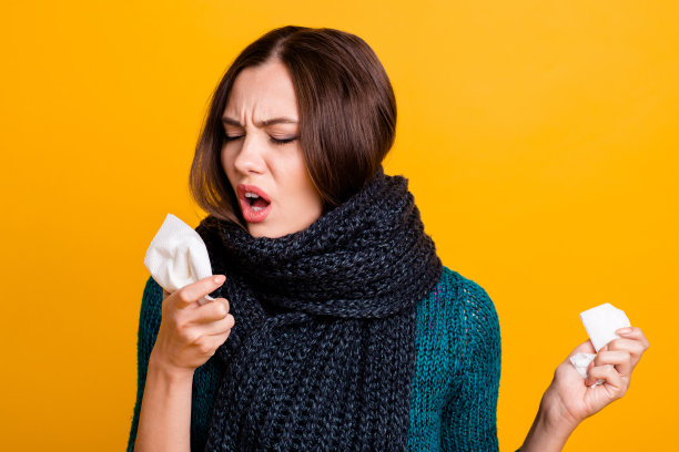 近距离的照片美丽的她她夫人遭受医学扁桃体炎，心绞痛肺炎柔软温暖的围巾围着脖子咳嗽餐巾穿绿色针织套衫套头衫孤立的黄色背景图片下载