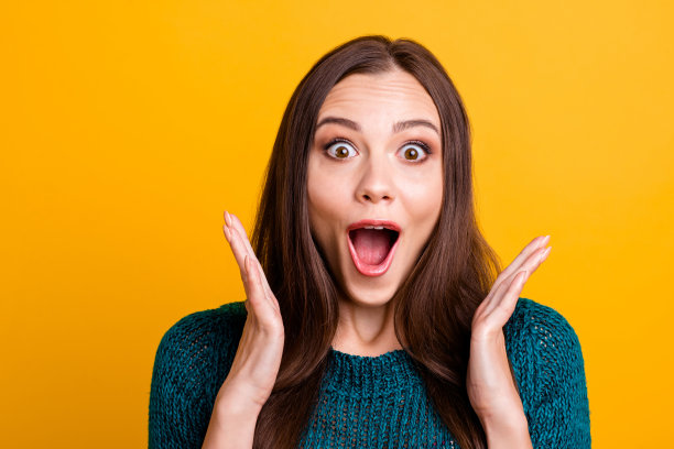 特写照片美丽的funky喊她，她的女子足球队球迷张开嘴，棕色的眼睛，看起来欣喜若狂拉拉队长穿绿色针织套衫，衣服孤立的黄色背景图片下载