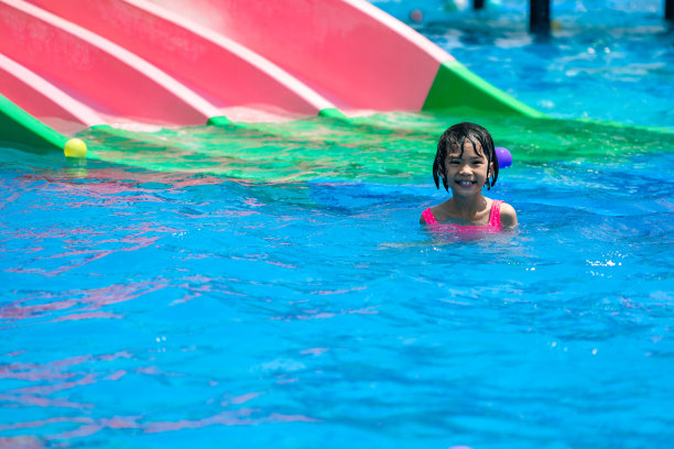 孩子们在暑假的时候在游泳池里玩滑块和游泳图片下载