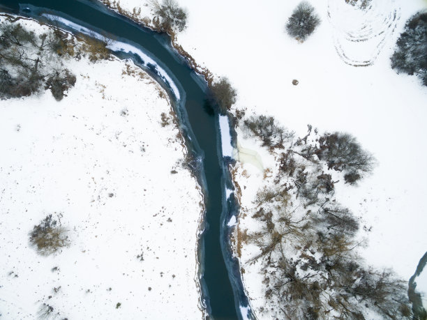 冬季的景观在河与森林之间的雪与鸟瞰的观点。无人机查看照片从无人机在阴天。空中俯瞰美丽的雪景图片下载