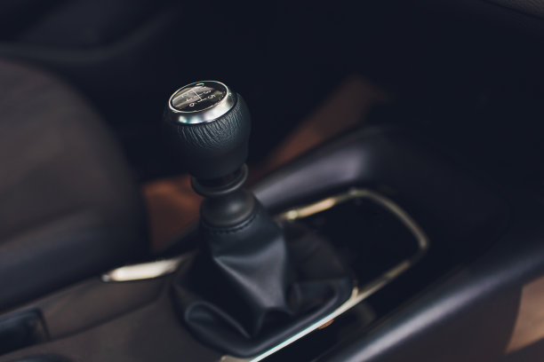 近距离查看变速杆换挡。手动变速箱。汽车内饰的细节。汽车传动。柔和的灯光。抽象的观点。图片下载