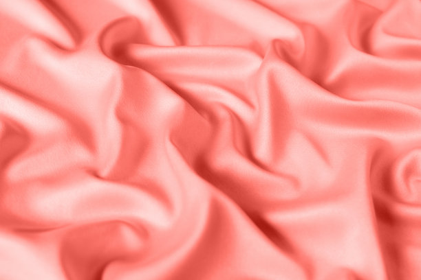 近距离的波纹丝绸织物。缎织物背景。粉色珊瑚的颜色。图片下载