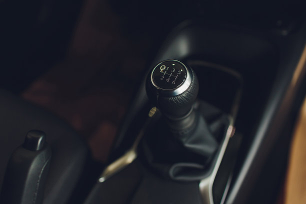 近距离查看变速杆换挡。手动变速箱。汽车内饰的细节。汽车传动。柔和的灯光。抽象的观点。图片下载