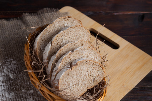 新鲜切成薄片的柳条碗放在橡木板上，上面撒有面粉，背景是亚麻织物。照片俯视图图片下载