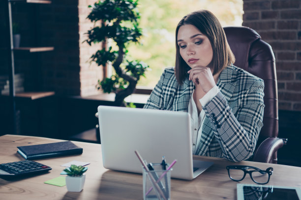近距离的照片，美丽的她，她的商务女士，最好的老板正在网上货币，商务聊天，电子邮件信件，细心的笔记本，桌子，坐大的办公椅，穿正式的格子西装图片下载