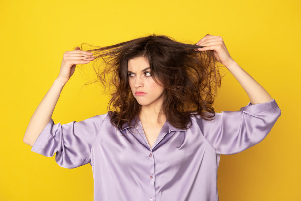 恼怒的年轻女孩看着她的皱巴巴的头发图片下载