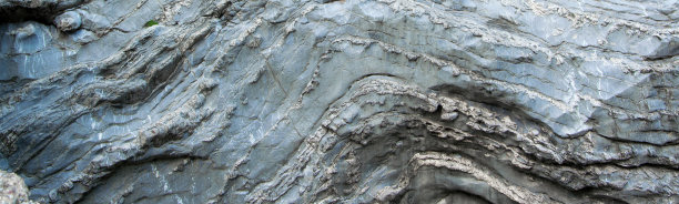 近距离观察自然起伏的岩层。抽象的设计图片下载