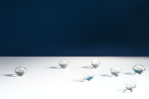 玻璃珠散落在素净的白色桌上图片下载