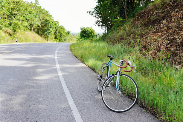 一辆老式自行车停在乡间的路上，停在阴凉处图片下载