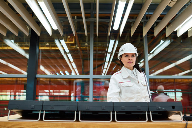 有经验的女工程师在工厂操作控制面板图片下载