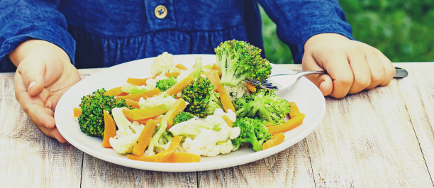 孩子吃蔬菜。夏天的照片。有选择性的重点图片下载